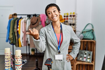 Wall Mural - Young hispanic woman shopkeeper smiling confident speaking at clothing store