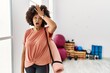 African american woman with afro hair holding yoga mat at pilates room surprised with hand on head for mistake, remember error. forgot, bad memory concept.