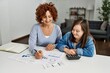 © Krakenimages.com - Mature mother and down syndrome daughter doing economy house together