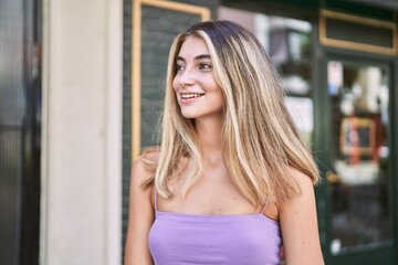 Poster - Young blonde girl smiling happy standing at the city.