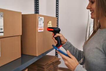 Canvas Print - Young blonde woman ecommerce business worker scanning packages using barcode reader at office