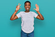 © Krakenimages.com - Young african american woman wearing casual white t shirt showing and pointing up with fingers number eight while smiling confident and happy.