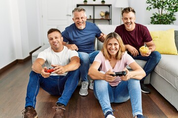 Sticker - Group of middle age friends smiling happy playing video game at home.