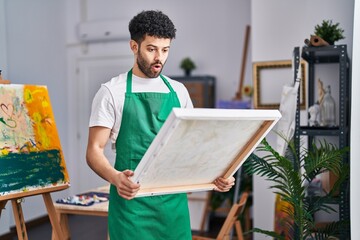 Poster - Arab man at art studio afraid and shocked with surprise and amazed expression, fear and excited face.