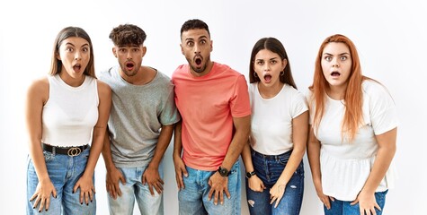 Poster - Group of young friends standing together over isolated background afraid and shocked with surprise and amazed expression, fear and excited face.