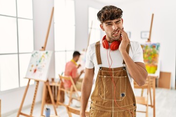 Sticker - Young hispanic man at art studio touching mouth with hand with painful expression because of toothache or dental illness on teeth. dentist