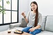 Young asian woman eating sushi at the living room