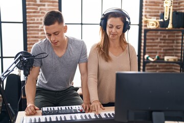 Poster - Man and woman musicians playing piano keyboard at music studio