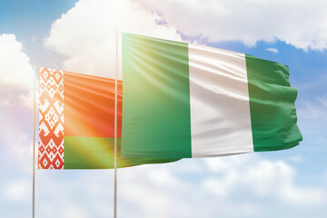 Sunny blue sky and flags of nigeria and belarus