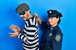 © Krakenimages.com - Middle age couple of hispanic woman and man wearing thief and police uniform looking to side, relax profile pose with natural face and confident smile.