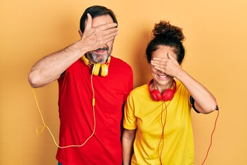 Sticker - Middle age couple of hispanic woman and man wearing sportswear and arm band smiling and laughing with hand on face covering eyes for surprise. blind concept.