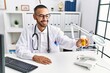 © Krakenimages.com - Young hispanic man wearing doctor uniform holding pills at clinic