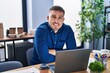 © Krakenimages.com - Young hispanic man business worker sitting with arms crossed gesture at office