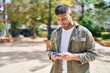 © Krakenimages.com - Young hispanic man smiling confident using smartphone at park