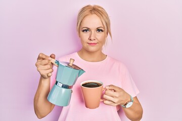 Canvas Print - Young blonde woman drinking a cup fresh coffee relaxed with serious expression on face. simple and natural looking at the camera.