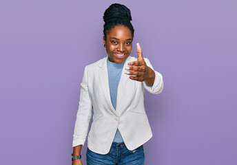 Sticker - Young african american woman wearing business clothes smiling friendly offering handshake as greeting and welcoming. successful business.