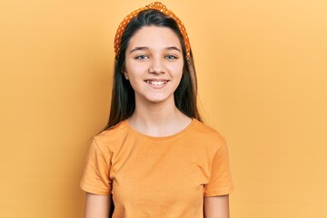 Sticker - Young brunette girl wearing casual orange t shirt looking positive and happy standing and smiling with a confident smile showing teeth