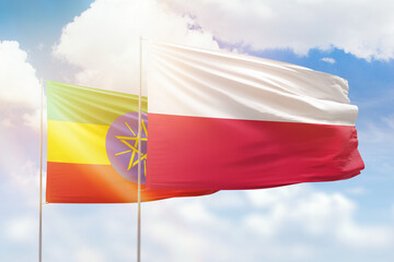 Sunny blue sky and flags of poland and ethiopia