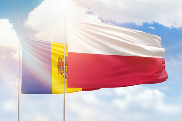 Sunny blue sky and flags of poland and moldova