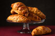 croissants on a glass stand on a dark background