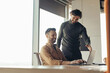 © Prostock-studio - Positive male colleagues discussing common project, using laptop, brainstorming for ideas at modern office, empty space