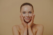 © VK Studio - Young beautiful woman with bare shoulders touching cheeks, enjoying her soft and smooth skin
