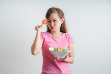 Asian woman eating a fresh salad isolated on white