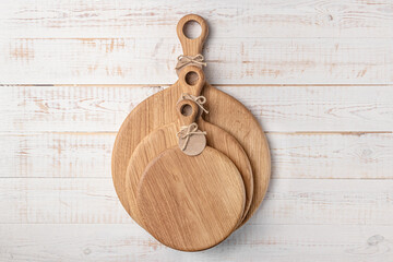 three round cutting board with a handle on a white wooden table. mockup of a food background with copy space, top view