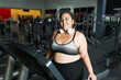 Cheerful overweight woman on the treadmill