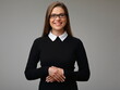 Happy smiling female teacher in strict black business dress with glasses keeps hands folding in front of her, isolated woman portrait.