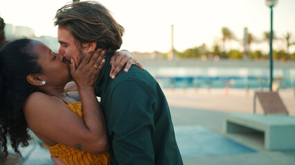 Closeup, a man and a woman kissing and joyfully communicate when they meet. Close-up of a happy young interracial couple.