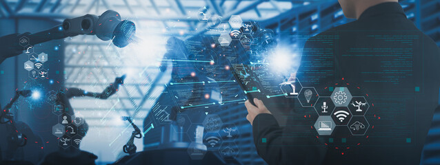 Wall Mural - industry engineer in factory,using visual smart tablet device,control automated robot arm machine le