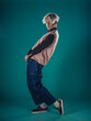 © qunica.com - Young adult man in casual outfit wear looking at camera, holding skateboard near face and standing at studio on blue background