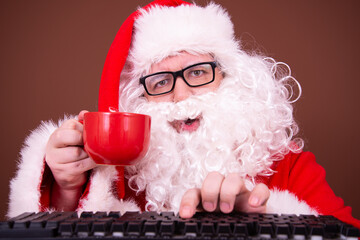 Santa Claus reads the news on the internet.