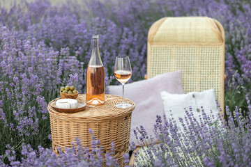 Sticker - Glass of white wine in a lavender field. Violet flowers on the background.