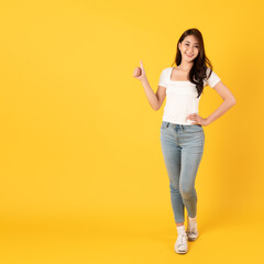 Wall Mural - Smiling asian woman white shirt on yellow background with thumbs up show appreciate