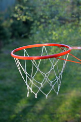 Backetball hoop in green yard or park, outside summer team game with ball and basket ring