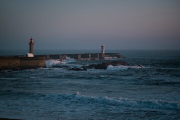 Poster - An ocean pier with a lighthouse after sunset.