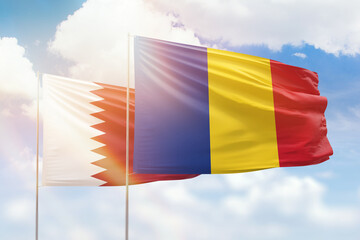 Sunny blue sky and flags of romania and qatar