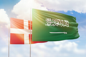 Sunny blue sky and flags of saudi arabia and denmark