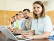 © JackF - Portrait of a young girl student studying with fellow students in a university auditorium on a laptop during class