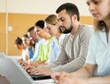 © JackF - Portrait of a student guy studying on a laptop during a class in a university auditorium