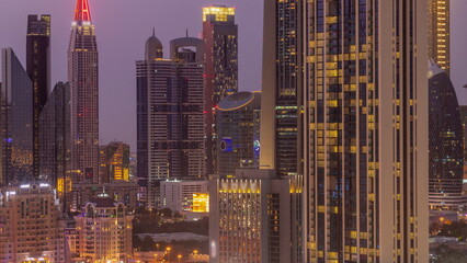 Row of the tall buildings around Sheikh Zayed Road and DIFC district aerial day to night timelapse in Dubai