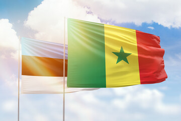 Sunny blue sky and flags of senegal and estonia