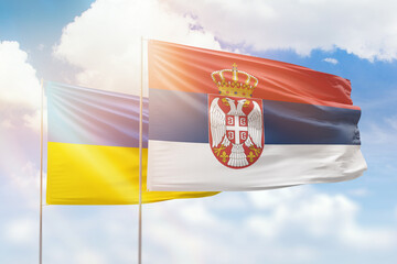 Wall Mural - Sunny blue sky and flags of serbia and ukraine