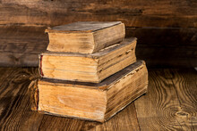 Old Worn Books On A Textured Wooden Table.