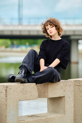 Portrait of cute teenager in total black outfit near the river