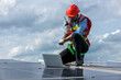 © kanpisut - Engineer working setup Solar panel at the roof top. Engineer or worker work on solar panels or solar cells on the roof of business building