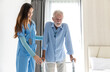 © kanpisut - Caregiver nurse take care a Senior patient. Nurse helping senior Man hand holding walker trying to walk