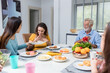 © kanpisut - Happy family spend time having lunch or dinner on table together. Senior man enjoying while communicating with their family in dining room. Dad fun with family dinner together.